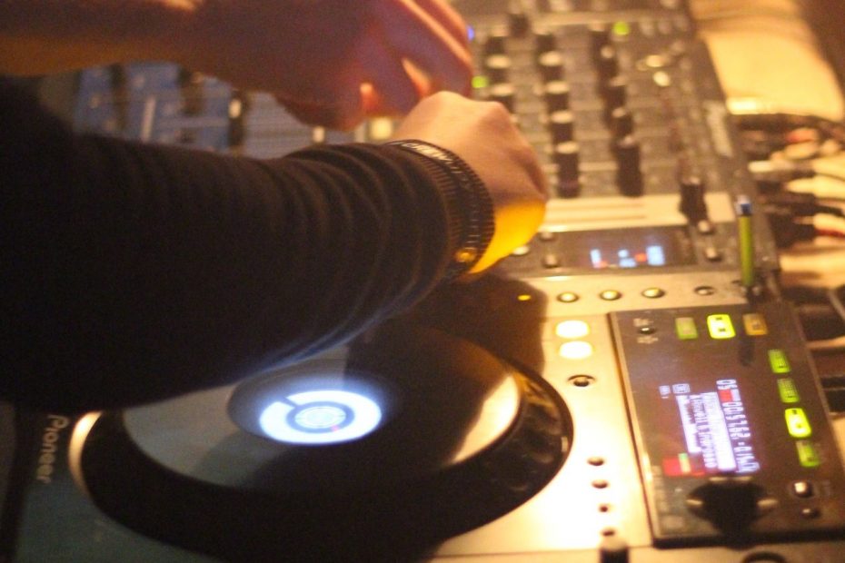 Eine Hand bedient ein DJ-Pult