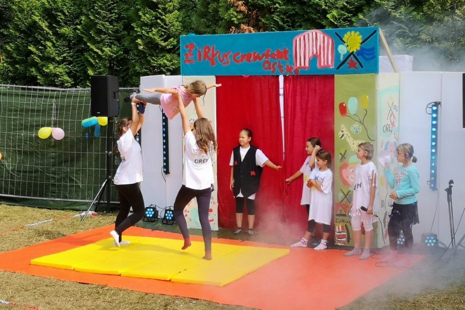 Kinder führen im Freien eine Artisten-Nummer bei einem Zirkus auf